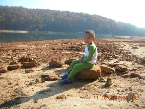 My youngest at 2, sitting on the "beach" at the lakehouse.